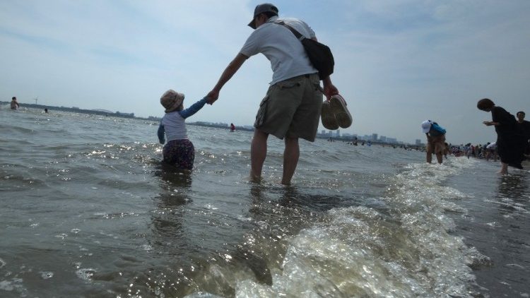 A father walks with his son at a beach (file photo)