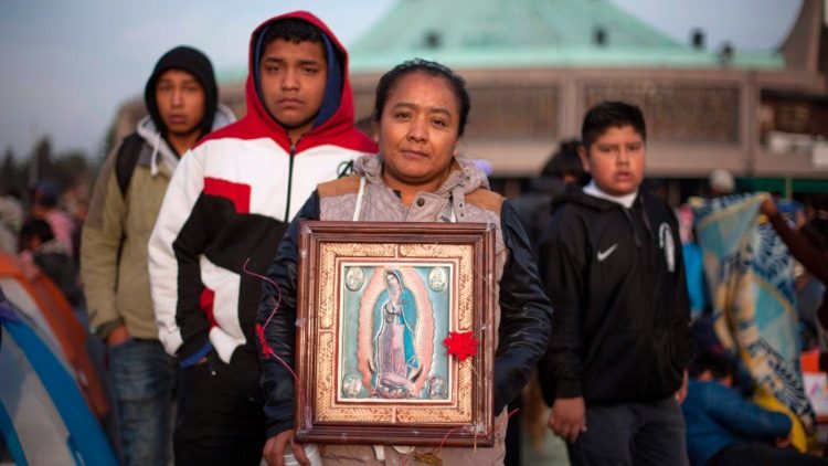 Des p&egrave;lerins posent avec une image de la Vierge dans le sanctuaire ND de Guadalupe.