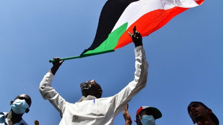 A Sudanese anti-coup protester waves the national flag