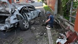 Um desarmador de minas inspeciona a área atingida por uma bomba de dispersão na Ucrânia.