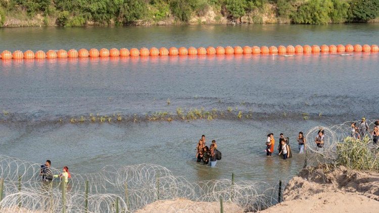 Migrantes caminan a lo largo de la frontera de Río Grande con México en Eagle Pass, Texas.
