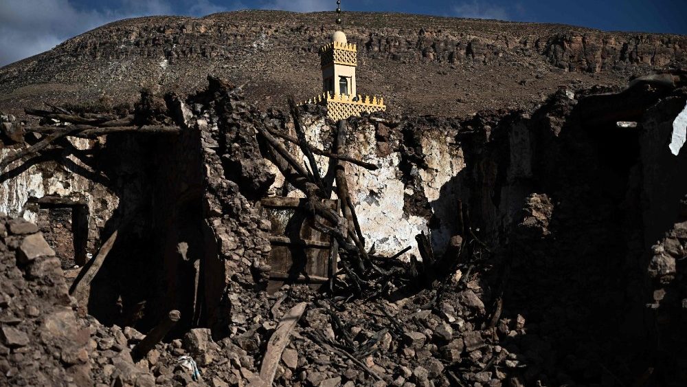 O minarete de uma mesquita danificada fica entre casas destruídas na aldeia de Ighermane, perto de Adassil, no centro de Marrocos, em 13 de setembro de 2023. (Photo by Philippe LOPEZ / AFP)