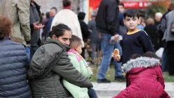 Refugiados miran mientras esperan cerca de un centro de registro de la Cruz Roja en Goris, Armenia.