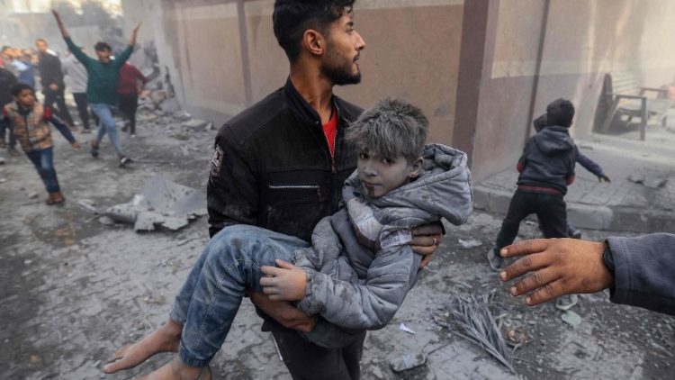 Muž nesoucí zraněné dítě po bombardování města Rafah v jižní části Pásma Gaza, 20. listopadu 2023