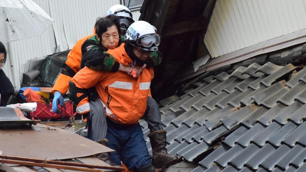 Residente é resgatado por bombeiros na cidade de Suzu, província de Ishikawa, em 3 de janeiro de 2024. (Foto de JIJI Press / AFP) 
