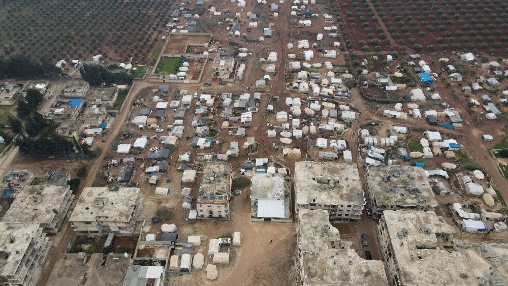 Uma vista aérea mostra prédios destruídos na cidade de Jindayris, no noroeste da província de Aleppo, em 1º de fevereiro de 2024, com as tendas da agência infantil da ONU, UNICEF, em primeiro plano para os deslocados após o grande terremoto do ano passado que atingiu a área. (Foto de Aaref WATAD/AFP)