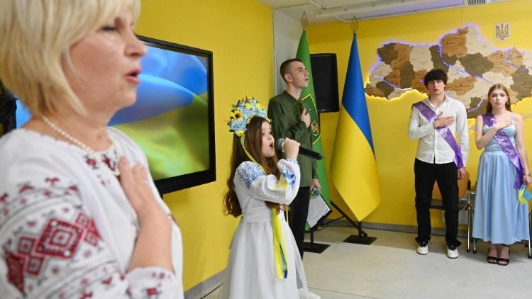Śpiewanie hymnu narodowego na zakończenie szkoły w podziemnej placówce edukacyjnej w Charkowie, 31 maja 2024 r.