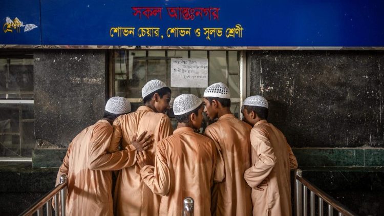 Estudantes de escola islâmica compram passagens de trem na estação de Kamalapur enquanto os serviços ferroviários de passageiros são retomados em Dhaka em 13 de agosto de 2024, dias após uma revolta liderada por estudantes que derrubou o governo de 15 anos da ex-primeira-ministra Sheikh Hasina. 