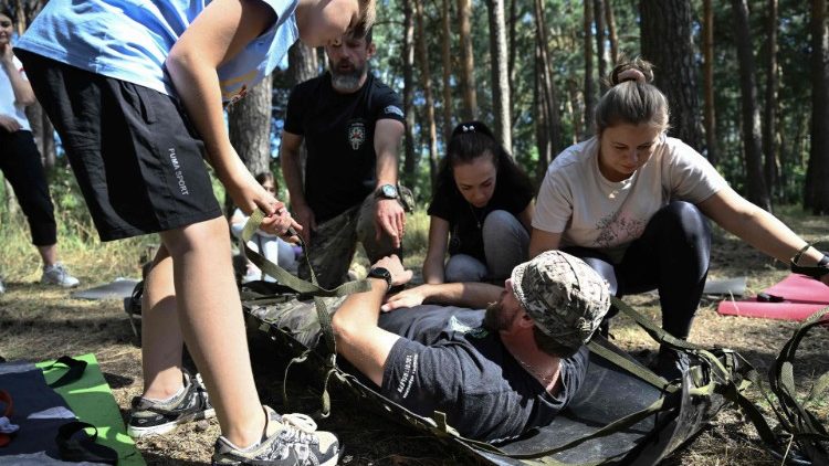 Pessoas participam de uma demonstração de primeiros socorros de emergência por paramédicos voluntários da organização voluntária Hospitalários da Ucrânia na cidade de Sumy em 17 de agosto de 2024, em meio à invasão russa da Ucrânia. (Foto de Genya SAVILOV / AFP)