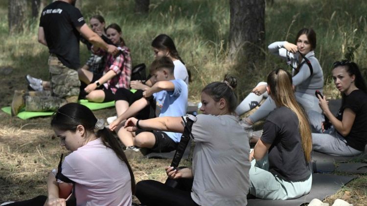Pessoas participam de uma demonstração de primeiros socorros de emergência por paramédicos voluntários da organização voluntária Hospitalários da Ucrânia na cidade de Sumy em 17 de agosto de 2024, em meio à invasão russa da Ucrânia. (Foto de Genya SAVILOV / AFP)