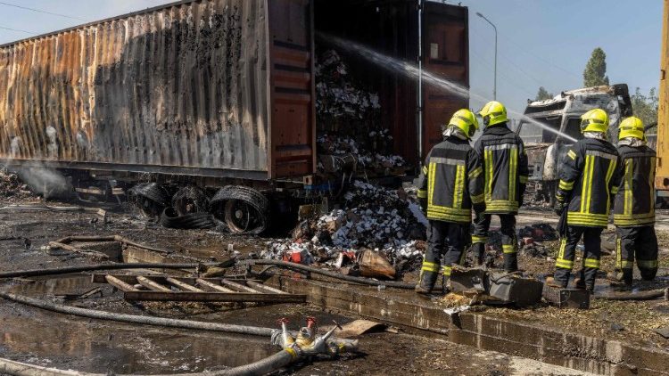 Bombeiros ucranianos apagam um incêndio em um local próximo a caminhões queimados após um ataque aéreo, na região de Odessa, em 26 de agosto de 2024, em meio à invasão russa na Ucrânia. (Photo by Oleksandr GIMANOV / AFP)