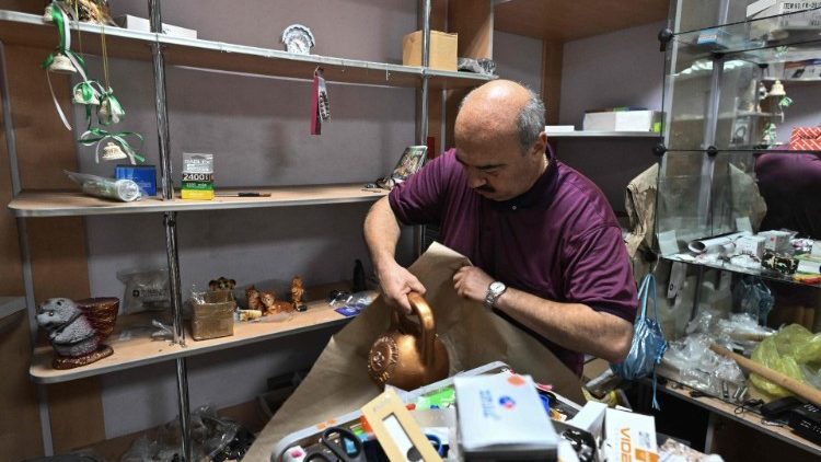 O dono da loja, Andrei, 52, arruma a loja enquanto se prepara para evacuar, em Myrnohrad, em 26 de agosto de 2024, em meio à invasão russa na Ucrânia. (Foto de Genya SAVILOV / AFP)