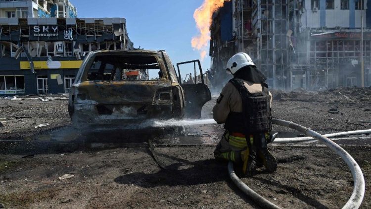 Um socorrista apaga um incêndio do lado de fora de um shopping após mísseis russos atingirem Kharkiv em 1º de setembro de 2024. (Photo by SERGEY BOBOK / AFP)