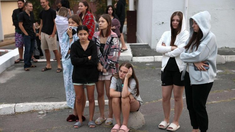 Alunos da Academia Internacional de Gestão de Pessoal observam equipes de emergência trabalhando para apagar um incêndio em um prédio de sua instituição educacional após um ataque de mísseis em Kiev em 2 de setembro de 2024, em meio à invasão russa na Ucrânia. (Foto de Anatolii STEPANOV / AFP)