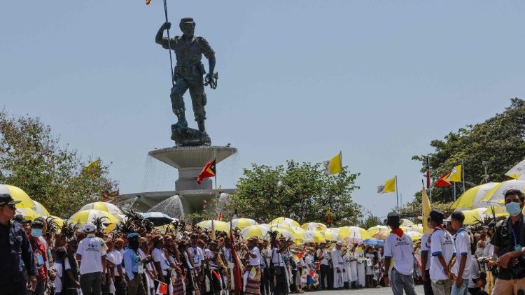 Fiéis católicos esperam a chegada do Papa Francisco em Díli. (Foto de Yasuyoshi CHIBA / AFP)