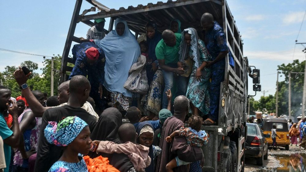 Pessoas afetadas pelas enchentes são assistidas por militares em Maiduguri em 12 de setembro de 2024. Graves enchentes na cidade de Maiduguri, no nordeste da Nigéria, mataram pelo menos 30 pessoas e forçaram 400.000 a deixarem suas casas, disseram autoridades em 11 de setembro de 2024. (Photo by Audu MARTE / AFP)