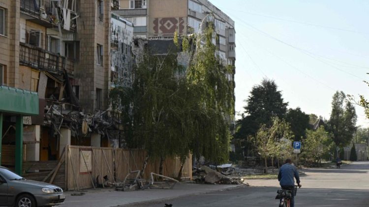 Um morador local anda de bicicleta passando por prédios fortemente danificados na cidade de Pokrovsk, região de Donetsk, em 20 de setembro de 2024, em meio à invasão russa da Ucrânia. As forças russas estão agora a apenas 10 quilômetros (seis milhas) de distância da cidade de Pokrovsk, uma cidade agora deserta, que já foi lar de 60.000, que Moscou tenta capturar há meses. (Foto de Genya SAVILOV / AFP)
