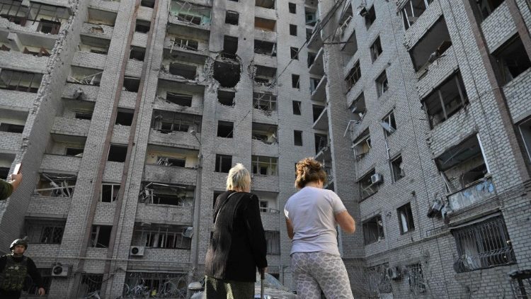 Moradores olham para um prédio danificado após um ataque russo na cidade de Kramatorsk, região de Donetsk, em 25 de setembro de 2024, em meio à invasão russa da Ucrânia. O ataque matou uma pessoa e feriu pelo menos 15, disse o governador regional Vadym Filashkin. (Foto de Genya SAVILOV / AFP)