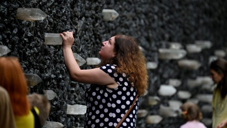 Uma mulher reza no Muro de Cristal do Choro no memorial de Babyn Yar para marcar o 83º aniversário da execução em massa de civis, principalmente judeus, pelos nazistas durante a Segunda Guerra Mundial, em Kiev, em 29 de setembro de 2024, em meio à invasão russa na Ucrânia. (Foto de Sergei SUPINSKY / AFP)