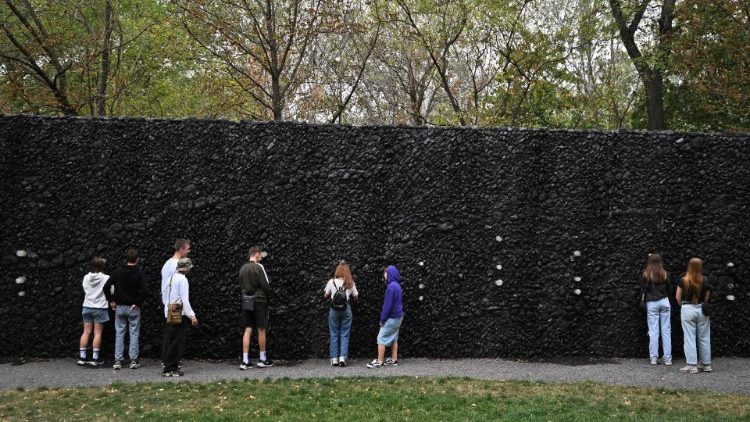 Pessoas rezam no Muro de Cristal do Choro no memorial de Babyn Yar para marcar o 83º aniversário da execução em massa de civis, principalmente judeus, pelos nazistas durante a Segunda Guerra Mundial, em Kiev, em 29 de setembro de 2024, em meio à invasão russa na Ucrânia. (Foto de Sergei SUPINSKY / AFP)
