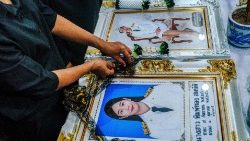 A mourner arranges a garland around the portrait of a victim of a school bus fire at Wat Khao Phraya Sangkharam School in Uthai Thani on October 2, 2024. (Photo by Chanakarn Laosarakham / AFP)
