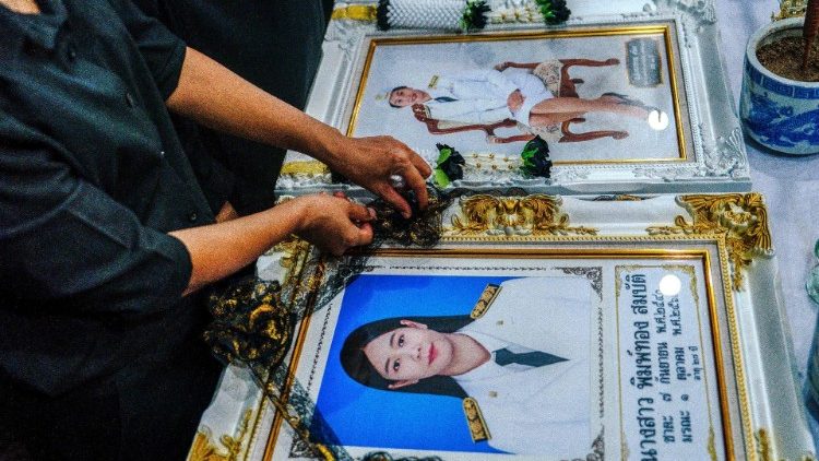 A mourner arranges a garland around the portrait of a victim of a school bus fire at Wat Khao Phraya Sangkharam School in Uthai Thani on October 2, 2024. (Photo by Chanakarn Laosarakham / AFP)
