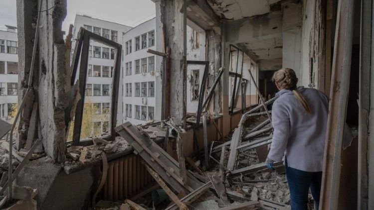 Uma mulher inspeciona os danos ao edifício Derzhprom, um arranha-céu histórico soviético, após um ataque de mísseis em Kharkiv em 29 de outubro de 2024. (Foto de Ivan SAMOILOV / AFP)