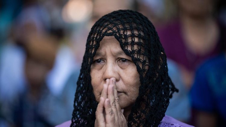 Une femme prie pour ses proches le jour de la Toussaint au cimetière chrétien de Kanasoekone dans le village de Wakema, le 2 novembre 2024.