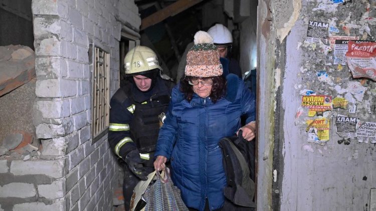 Equipes de resgate do Serviço de Emergência Estatal da Ucrânia evacuam um morador local de um prédio de vários andares, danificado após um ataque aéreo em Kharkiv em 8 de novembro de 2024, em meio à invasão russa na Ucrânia. (Foto de SERGEY BOBOK / AFP)