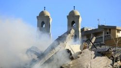 Uma igreja atrás de um prédio destruído após um ataque aéreo israelense que teve como alvo o bairro de Hadath, nos subúrbios ao sul de Beirute, em 17 de novembro de 2024.