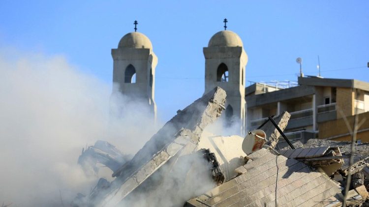 Uma igreja atrás de um prédio destruído após um ataque aéreo israelense que teve como alvo o bairro de Hadath, nos subúrbios ao sul de Beirute, em 17 de novembro de 2024.