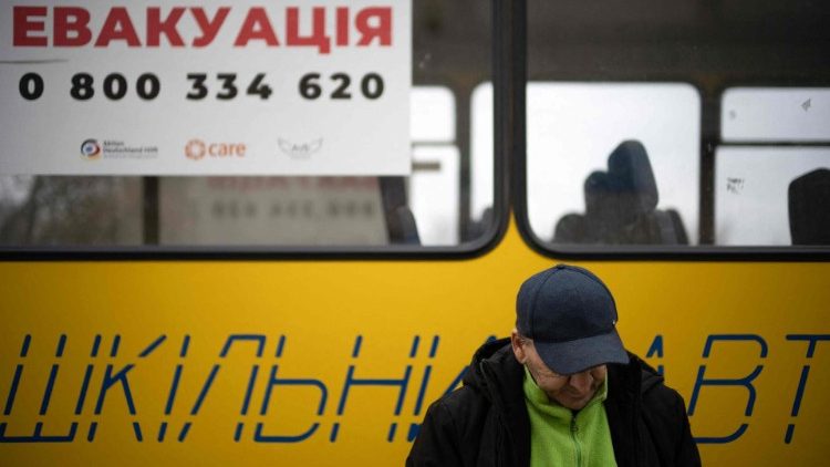 Un uomo sfollato dalla città di Toretsk, nel Donbass davanti a un autobus 