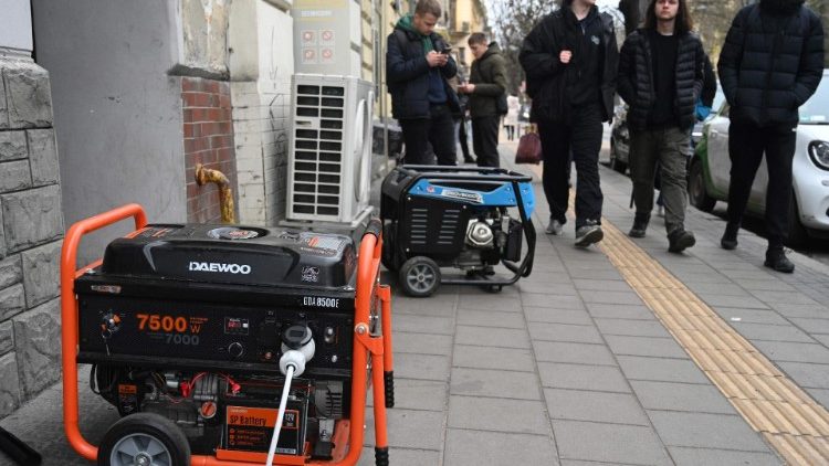 Moradores locais passam por geradores elétricos que fornecem eletricidade para um café durante uma queda de energia em Lviv em 28 de novembro de 2024, em meio à invasão russa da Ucrânia. Mais de um milhão de ucranianos ficaram sem energia em temperaturas congelantes em 28 de novembro de 2024 após um ataque massivo de mísseis e drones russos em todo o país. (Foto de YURIY DYACHYSHYN / AFP)