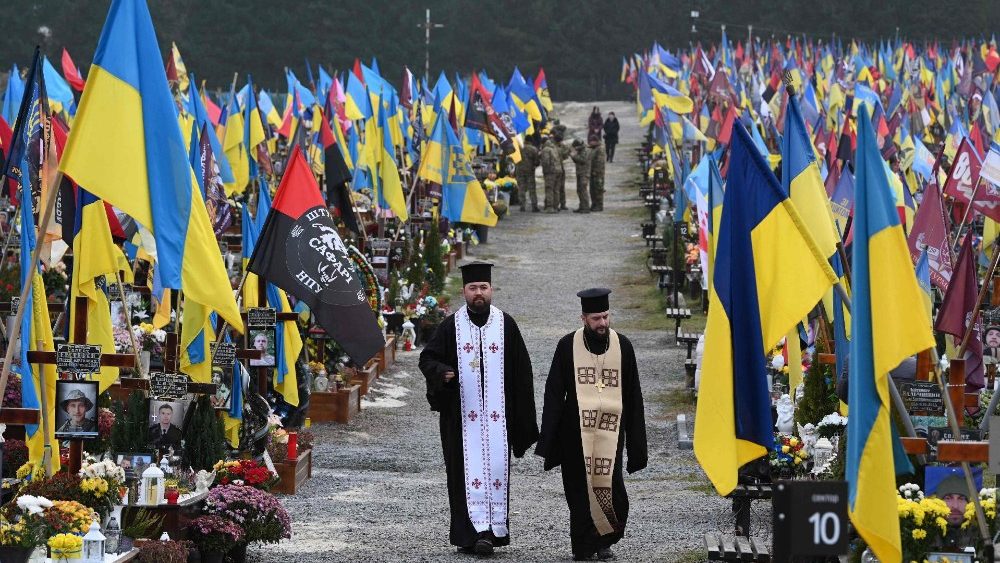Sacerdotes em cemitério de Lviv. (Photo Yuriy Dyachyshyn/AFP)