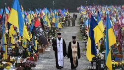 Sacerdotes caminham pelo cemitério Lychaklv, em Lviv, em 6 de dezembro de 2024.