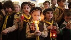 Des petites scouts ukrainiennes tiennent en main la lumière de la paix de Bethléem, dans un abri du métro de Kiev, en Ukraine, le 15 décembre 2024. 