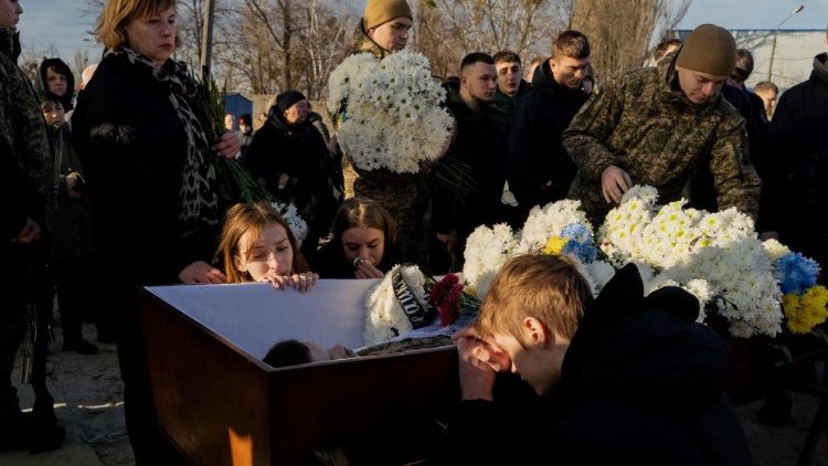 Parentes e amigos choram ao lado do caixão do falecido militar ucraniano Danylo Bobrykov, indicativo "Harvey", durante cerimônia fúnebre em Kiev em 2 de janeiro de 2025, em meio à invasão russa da Ucrânia. (Foto de Tetiana DZHAFAROVA / AFP)