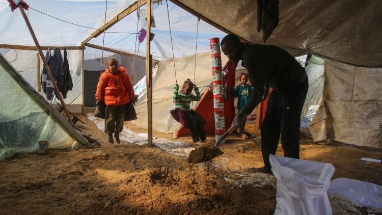 A displaced Palestinian family in their tent