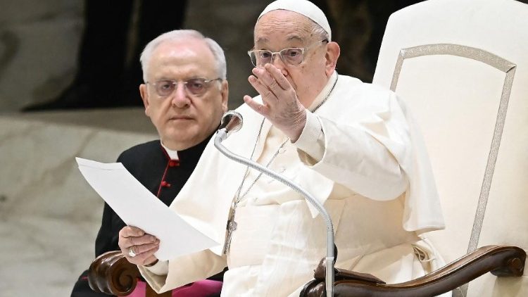 ርዕሰ ሊቃነ ጳጳሳት ፍራንቸስኮስ በቫቲካን በሚገኘው በጳውሎስ 6ኛ የስብሰባ አዳራሽ ውስጥ ሆነው የሚያሳይ ምስል 