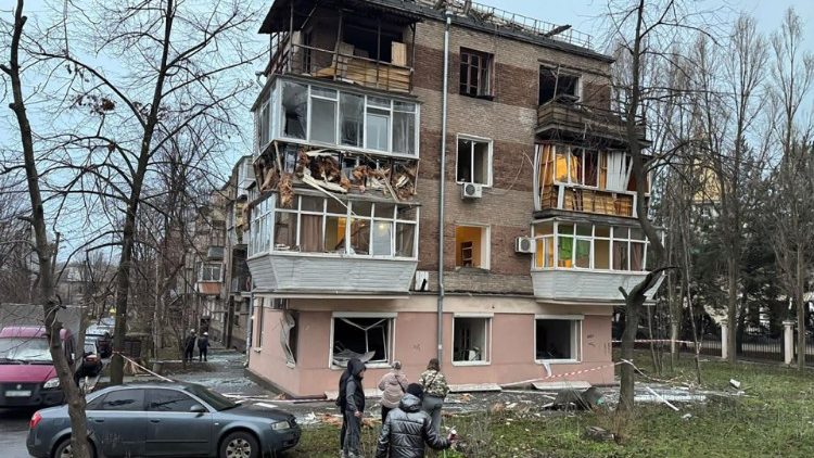 Nesta fotografia de folheto tirada e divulgada pela Polícia Nacional da Ucrânia em 18 de janeiro de 2025, moradores locais estão ao lado de um prédio residencial danificado após um ataque de foguete em Zaporizhzhia, em meio à invasão russa da Ucrânia. (Photo by Handout / National Police of Ukraine / AFP) 