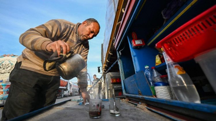 A driver makes tea next to his truck loaded with aid as he waits to cross into Gaza from the Egyptian side of the Rafah border