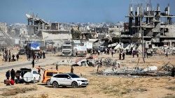 People gather as trucks carrying humanitarian aid arrive in the southern Gaza Strip on January 21