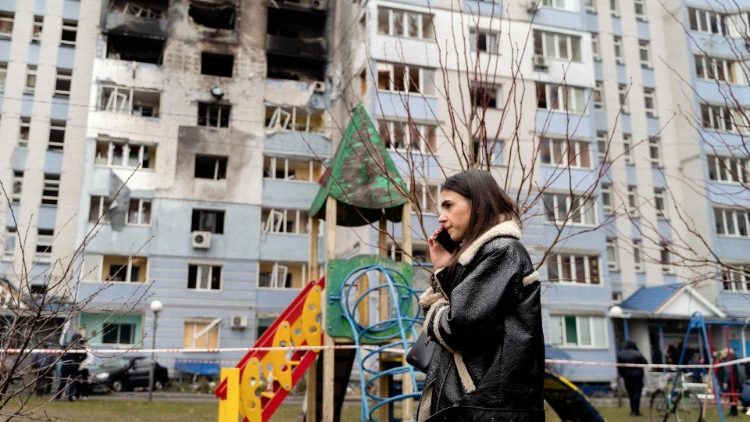 Uma mulher fala ao telefone ao lado de um prédio residencial após um ataque de drones na região de Kiev em 24 de janeiro de 2025, em meio à invasão russa da Ucrânia. (Foto de Tetiana DZHAFAROVA / AFP)