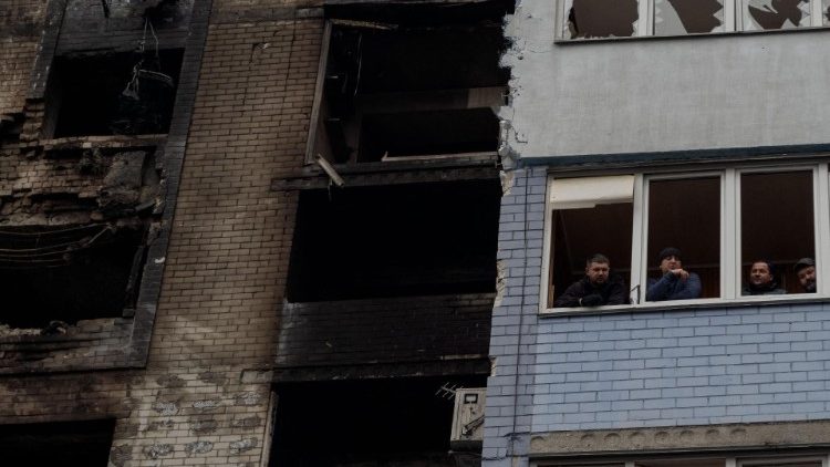 Moradores locais olham de uma janela quebrada após ataques aéreos russos na região de Kiev em 24 de janeiro de 2025, em meio à invasão russa da Ucrânia. (Foto de Tetiana DZHAFAROVA / AFP)