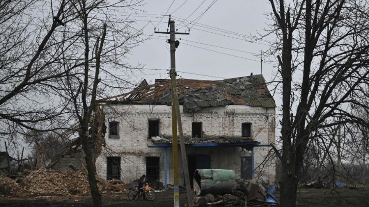 Um morador local empurra sua bicicleta na frente de um prédio destruído na vila de Novopavlivka, região de Dnipropetrovsk, em 25 de janeiro de 2025, em meio à invasão russa da Ucrânia. (Foto de Genya SAVILOV / AFP)