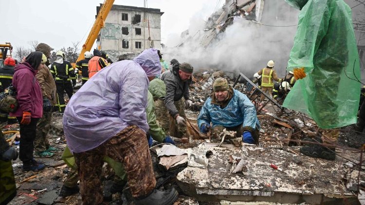 Moradores limpam escombros de um prédio após um ataque de míssil em Poltava, em 1º de fevereiro de 2025, em meio à invasão russa na Ucrânia. (Foto de SERGEY BOBOK / AFP)