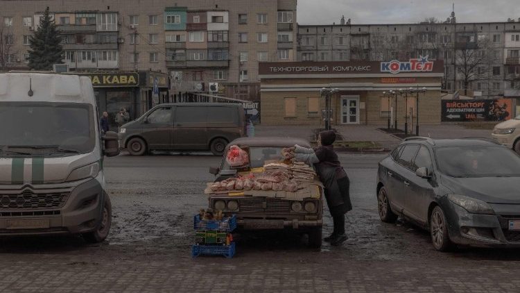 Uma mulher vende carne em uma rua em Druzhkivka, região de Donetsk, em 2 de fevereiro de 2025, em meio à invasão russa da Ucrânia. (Foto de Roman PILIPEY / AFP)
