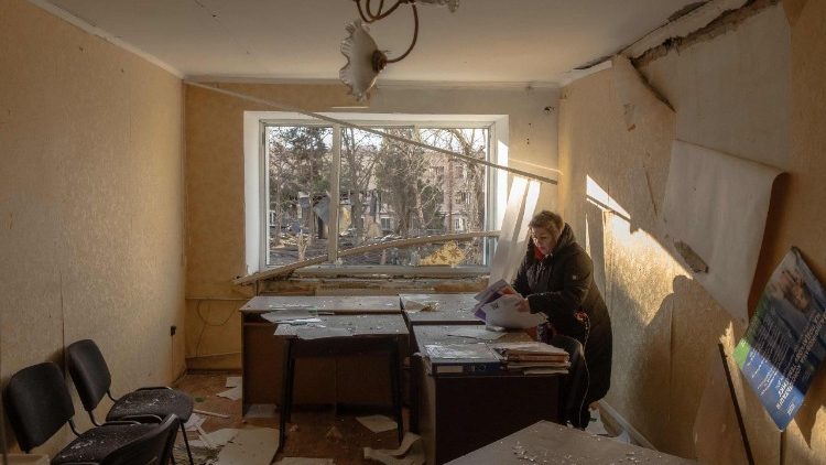 Uma mulher coleta documentos em um prédio danificado perto do local de um ataque de míssil em Izyum, região de Kharkiv, em 4 de fevereiro de 2025, em meio à invasão russa da Ucrânia. Um ataque de míssil russo em 4 de fevereiro de 2025 na cidade ucraniana de Izyum, brevemente ocupada pela Rússia em 2022, matou cinco pessoas e feriu mais três dúzias, disseram autoridades. (Foto de Roman PILIPEY / AFP)