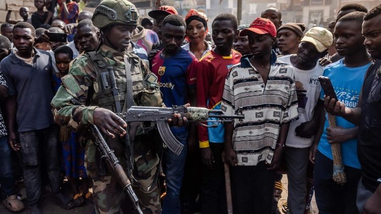 Un membro dell'M23 e alcuni giovani abitanti di Bukavu