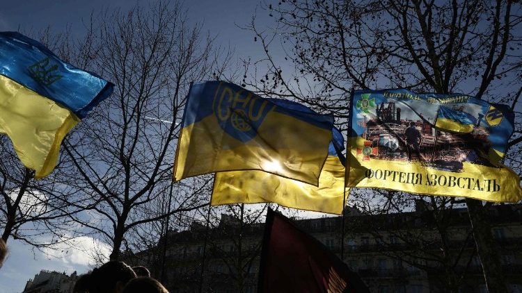 Manifestantes seguram bandeiras ucranianas durante um protesto em apoio à Ucrânia na véspera do terceiro aniversário da invasão russa ao país, na Place de la Republique, em Paris, em 23 de fevereiro de 2025. (Foto de ALAIN JOCARD / AFP)